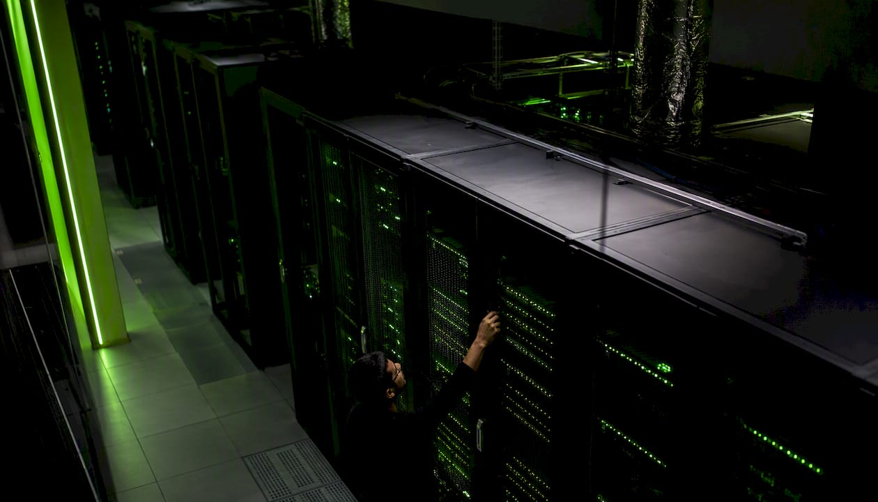 Neon-lit data center server racks with cable plug