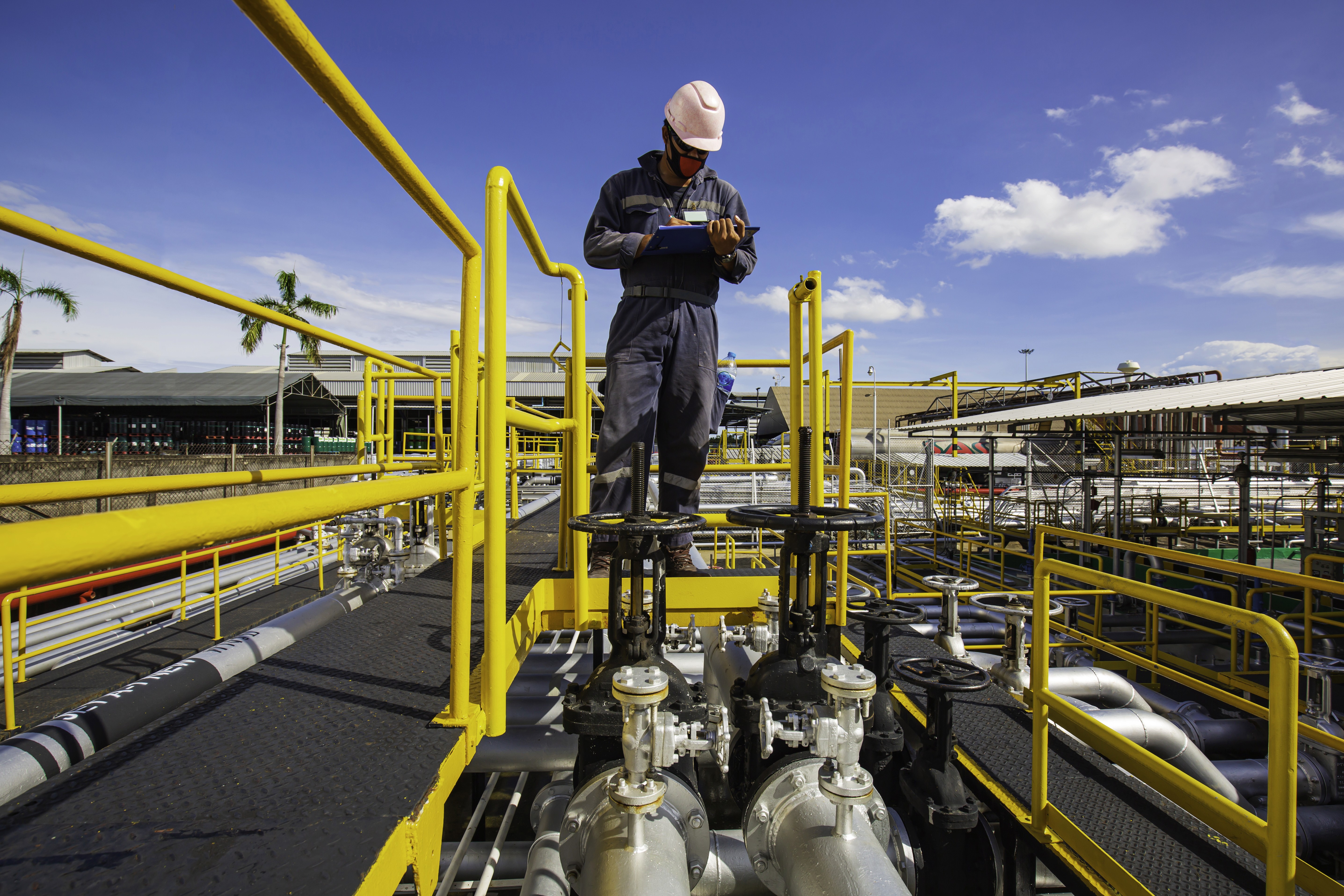 Trabalhador em uma obra de construção civil, utilizando EPIs, de braços cruzados