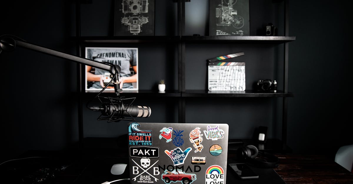 Creative design office interior with netbook with colorful stickers on table near dark shelf with sc