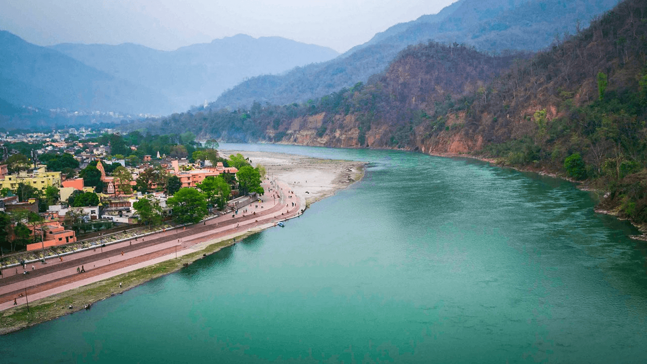 Adventure sports in Rishikesh with river rafting on the Ganga, mountains in the backdrop, and outdoor activities along the riverside.
