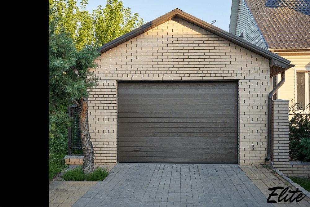 Modern brown garage door on a brick home installed by Elite Garage Door in NWA.
