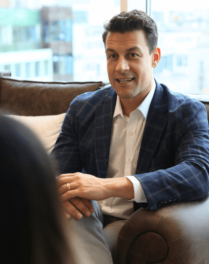 Smiling legal professional in conversation during a meeting, representing collaboration and confidence in a modern legal environment.