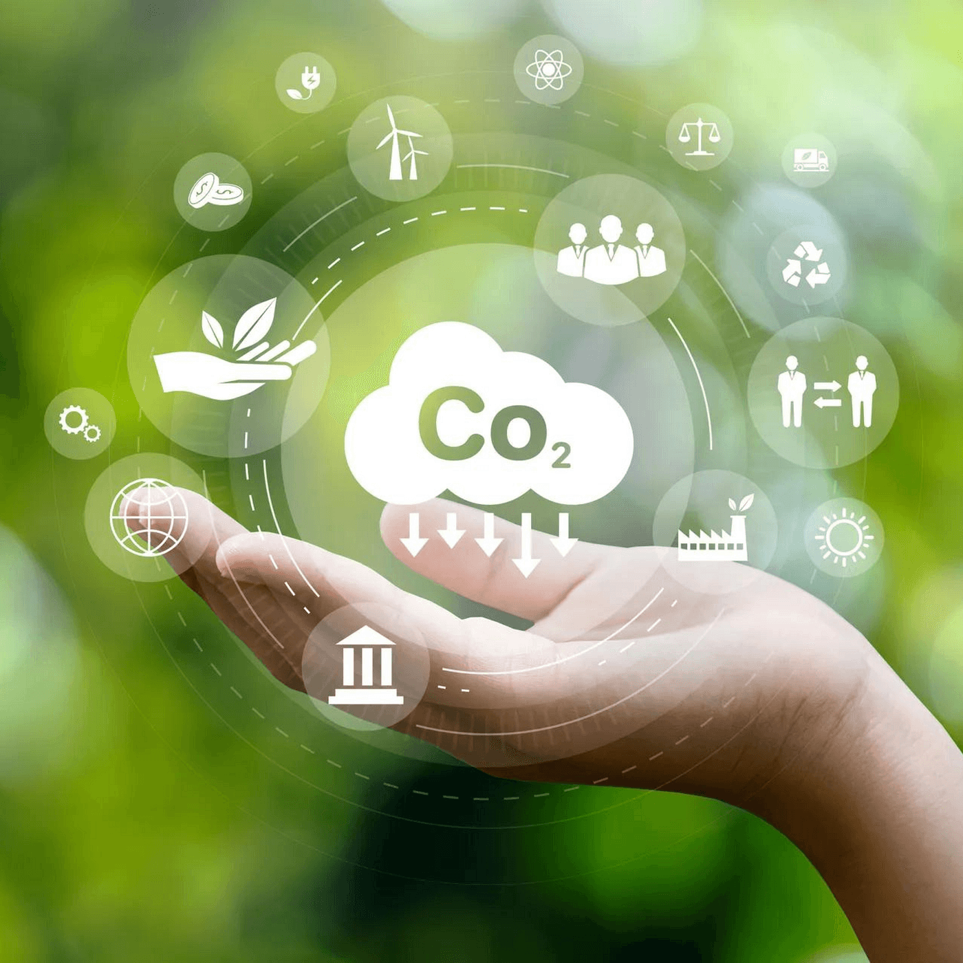 A young person with curly hair smiles at the camera while sitting in front of a laptop against a dark background.