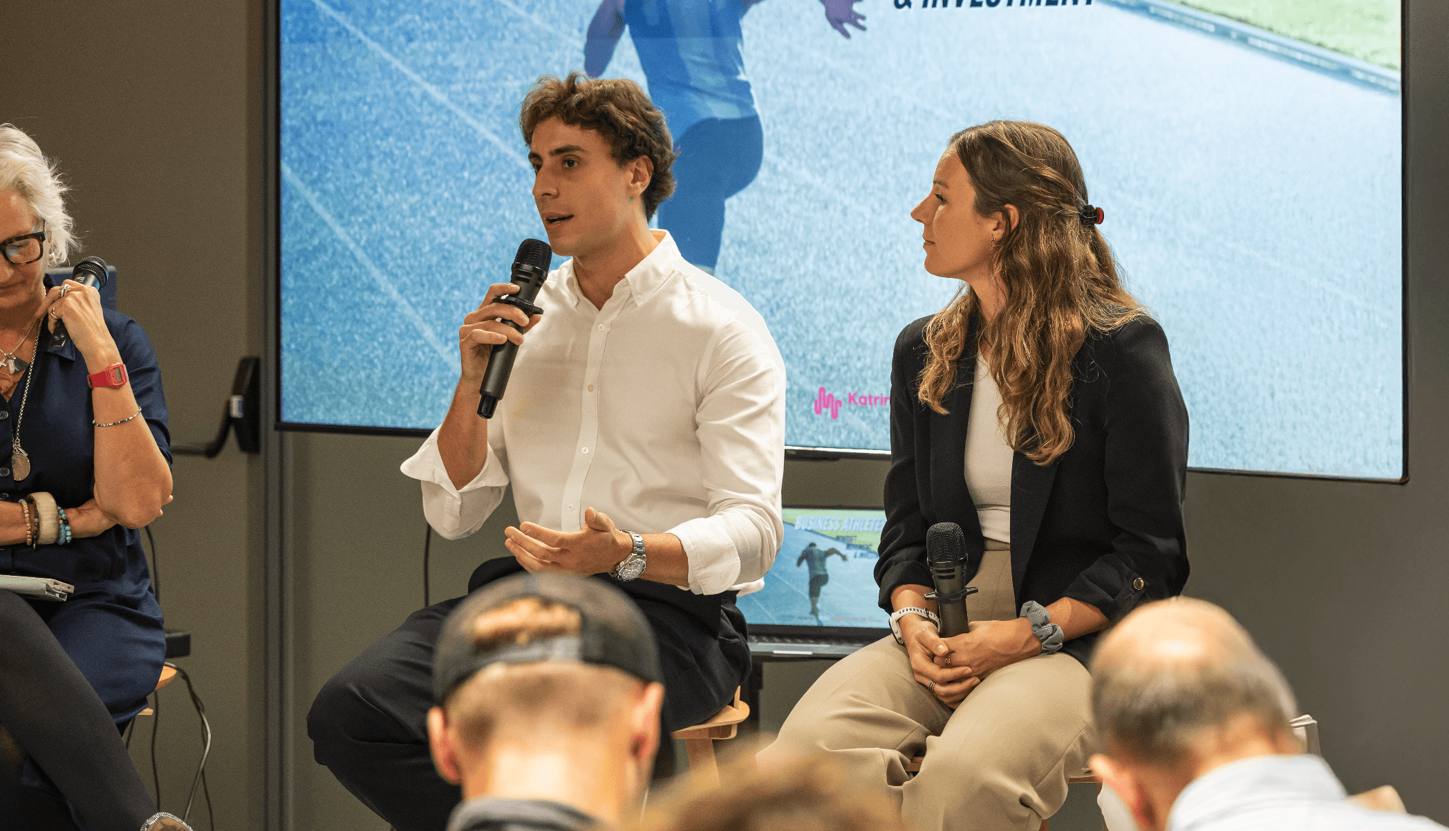 Collaborative work session overhead view of six people collaborating at a rustic wooden table with coffee, papers, and a laptop