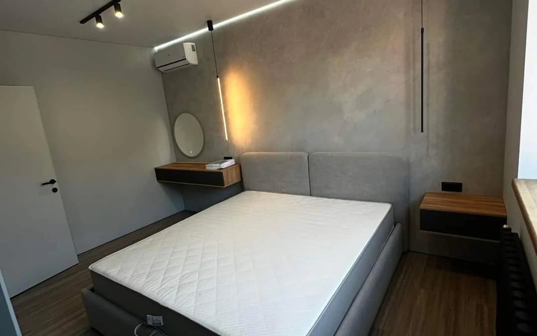 Espace commercial (salon de beauté) rénové : moulures murales bleu nuit, miroirs dorés, luminaires suspendus, parquet en chevrons.