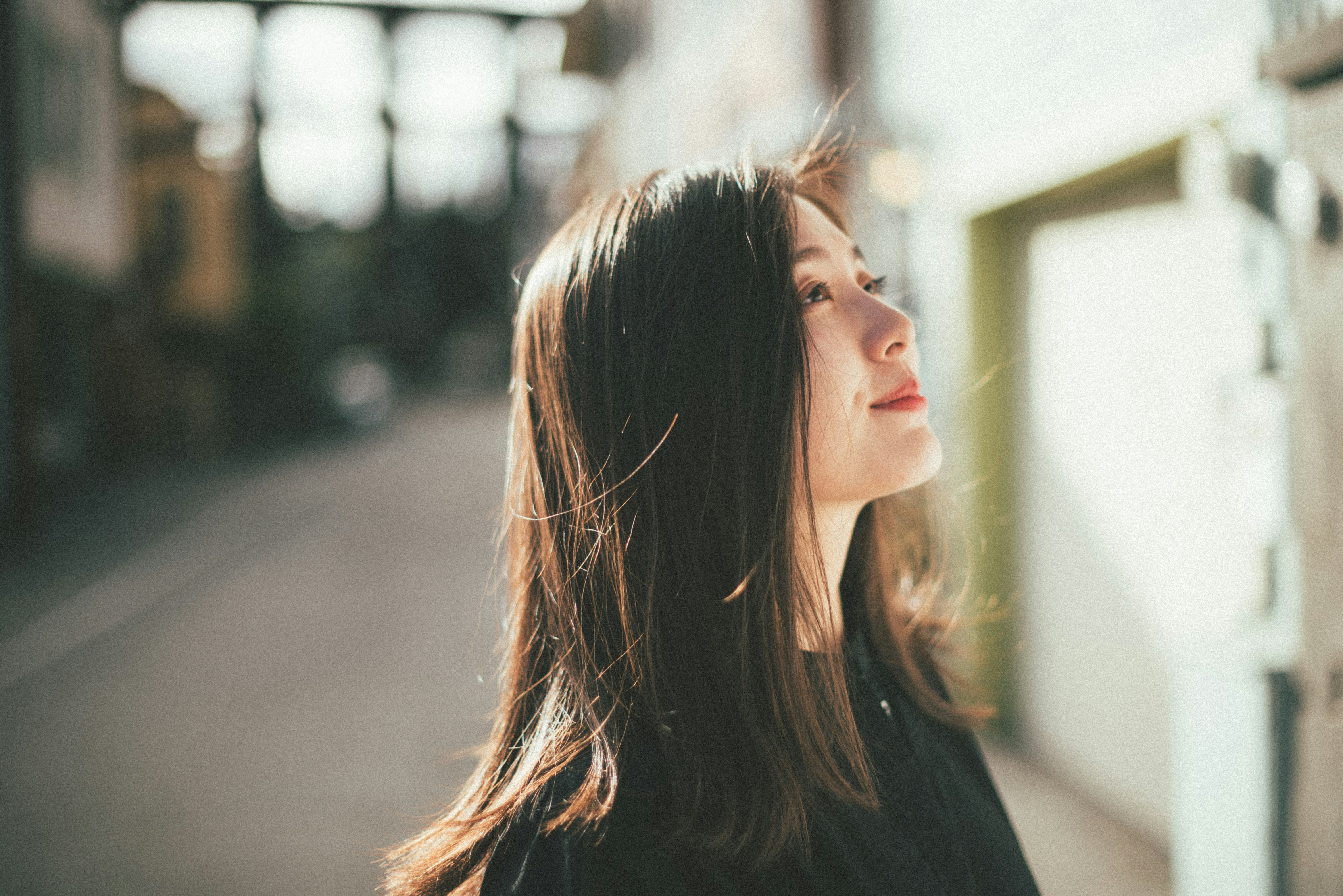 Young woman looking up outdoors with hair blowing