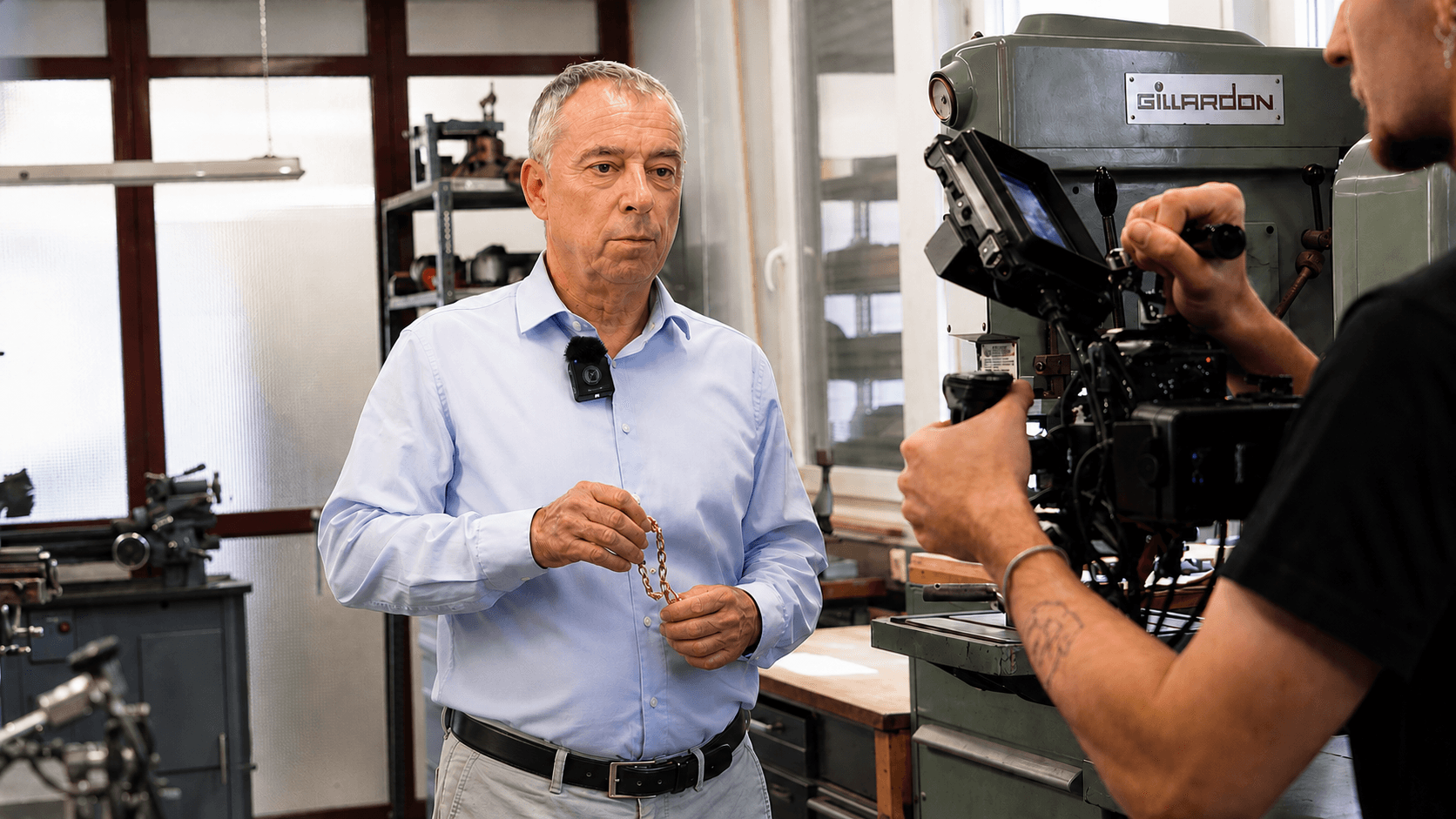 Mann im Hemd steht vor einer Kamera in einer industriellen Umgebung und wird für ein professionelles Video Interview gefilmt. Das Bild zeigt Content Produktion, Unternehmensvideo und authentische Markenkommunikation für Industrieunternehmen.