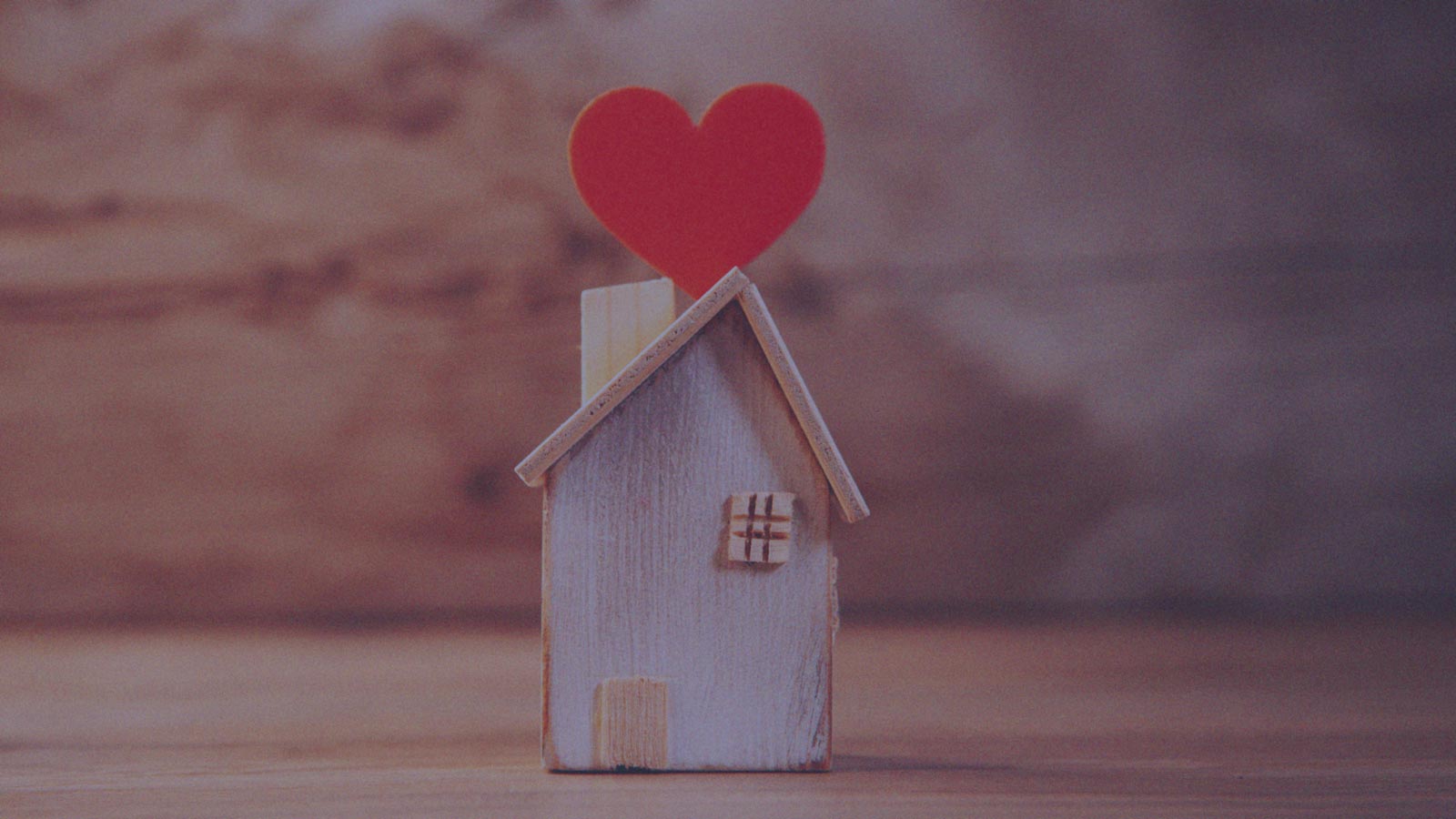 Foto de una casa pequeña de madera conun corazón en su techo, en la columna "El lugar de la familia" de IdePaís. 
