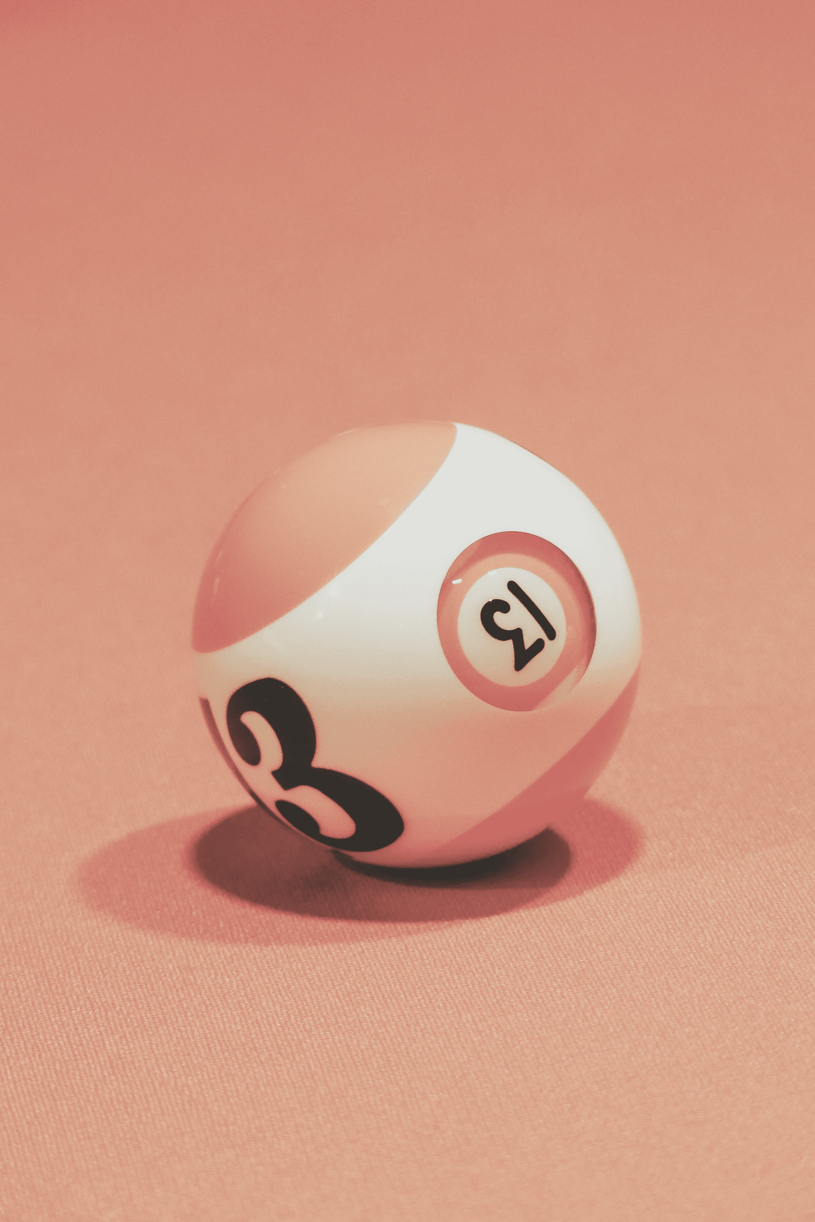 Close-up portrait of a person wearing a gray insulated hooded jacket with the hood up, showing their face framed by the hood against a light background.