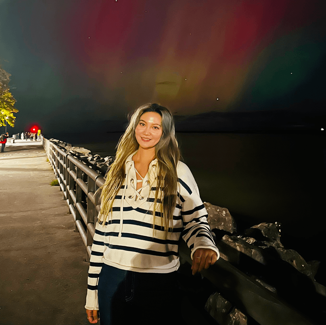 Person with yellow rain jacket looking over at mountains.