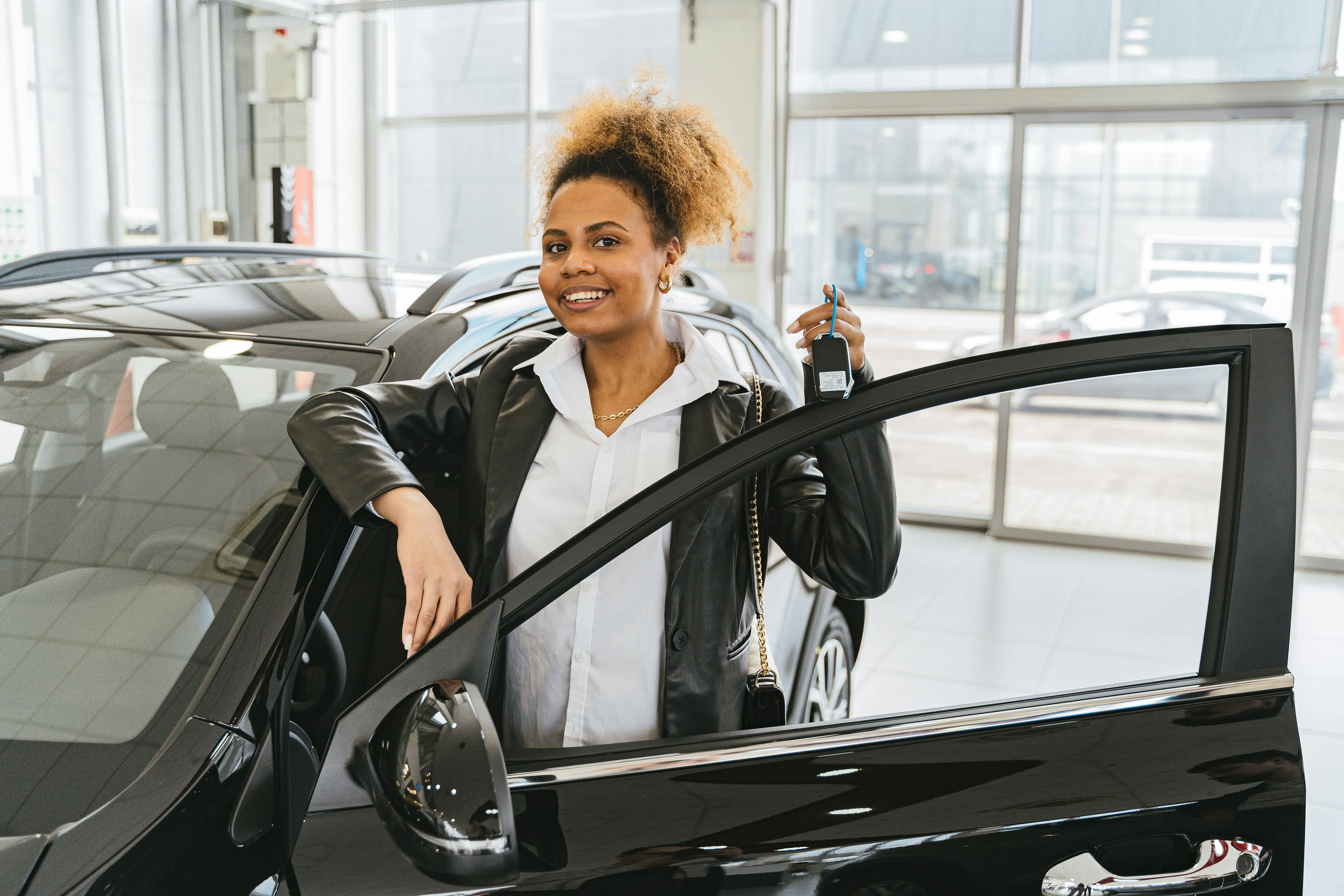 Cliente souriante recevant les clés de sa nouvelle voiture.