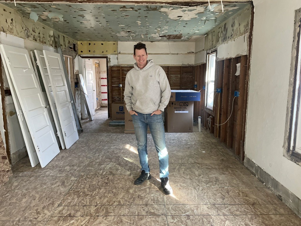 George Morgan standing inside an exposed-wall home renovation