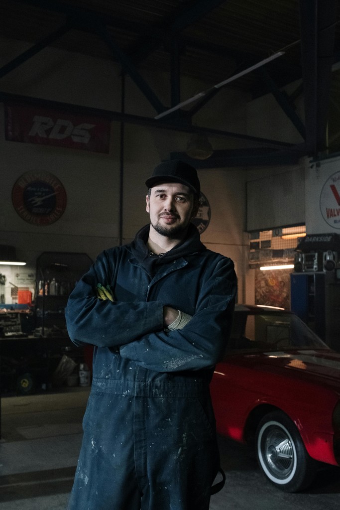 Guy in an auto shop looking at the camera