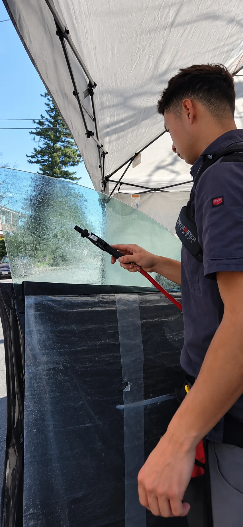 Jaylen preparing window film under the mobile canopy