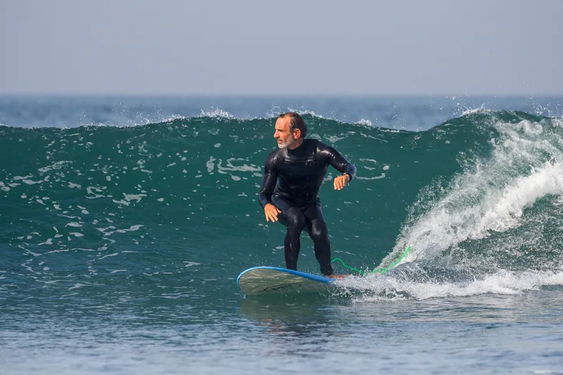 urfista cabalgando una ola en Tarifa durante una clase con Explora Watersports, España.