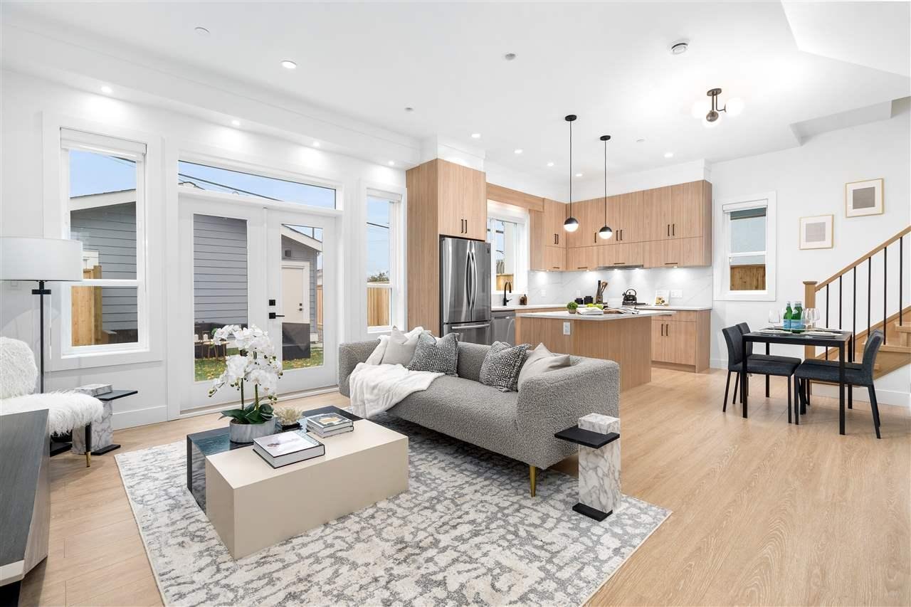 A modern living room featuring a sleek sofa, coffee table, and an open kitchen area with warm lighting.