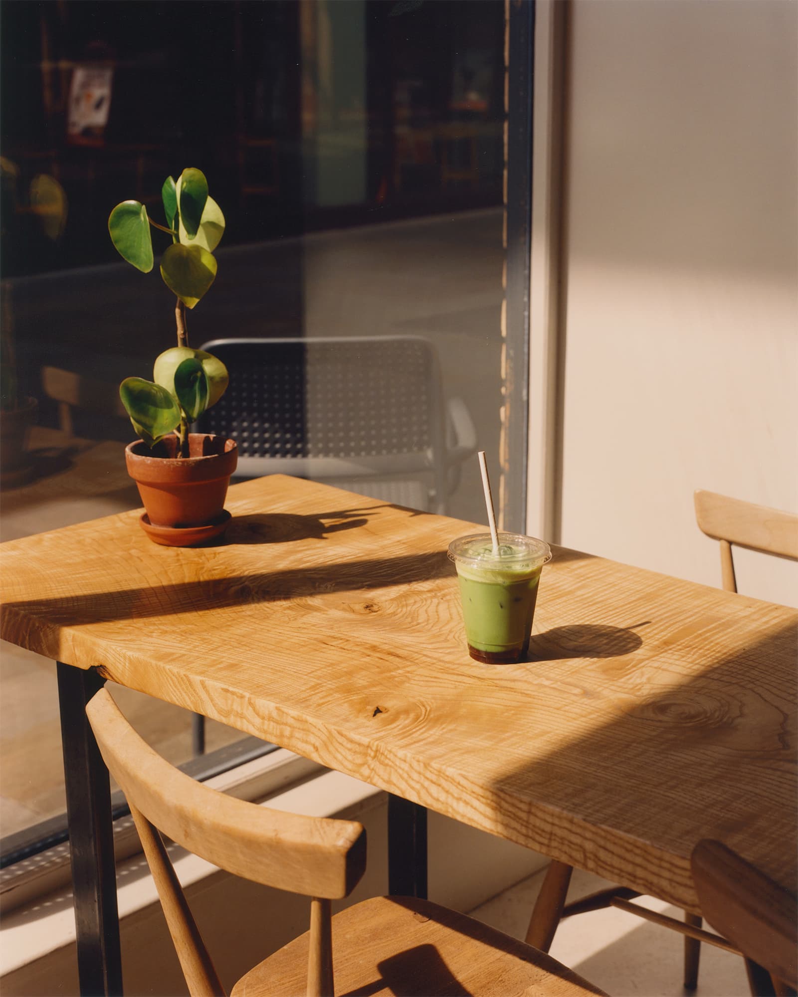 A green cup on a table inside a NKORA Coffee Shop