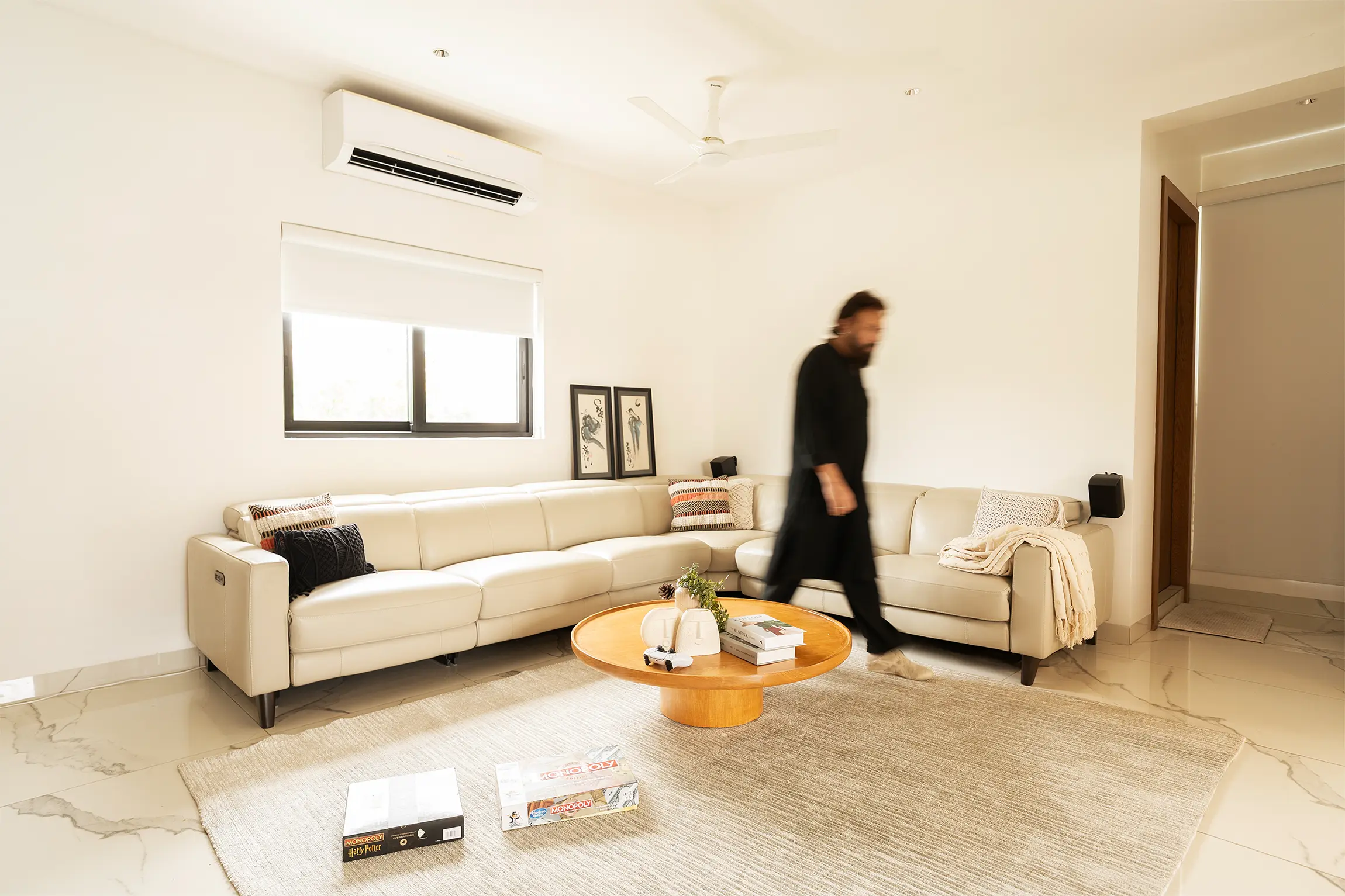 Neutral palette softens modern interior while warm design textures and elegant daylight define serene spatial harmony.