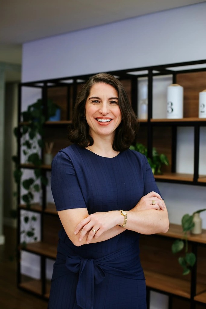 Empreendedora com postura profissional e feliz trabalhando no computador, representando o crescimento ao migrar de MEI para CNPJ.