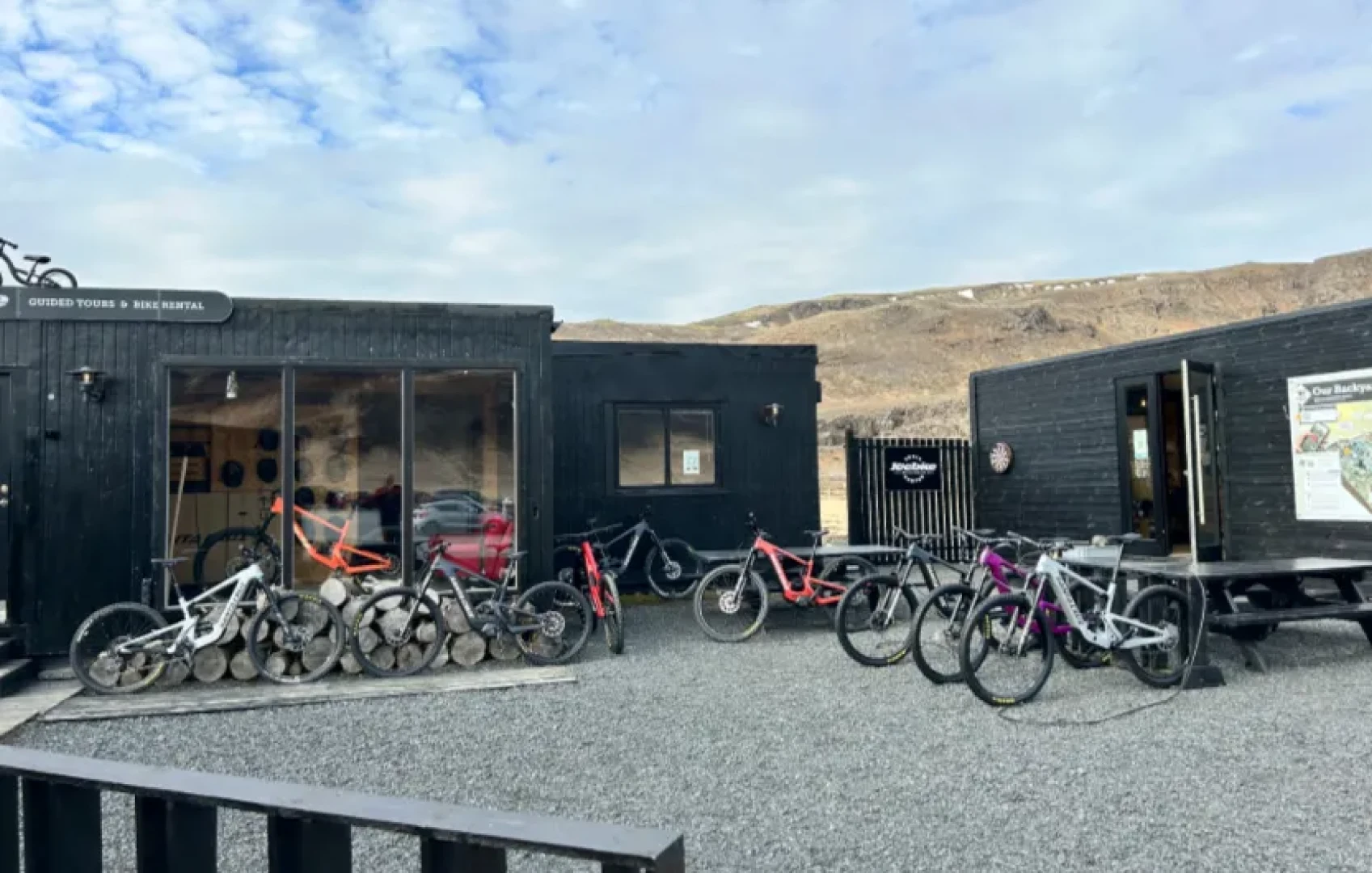 Exterior small black houses of Icebike Trailcenter in Reykjadalur
