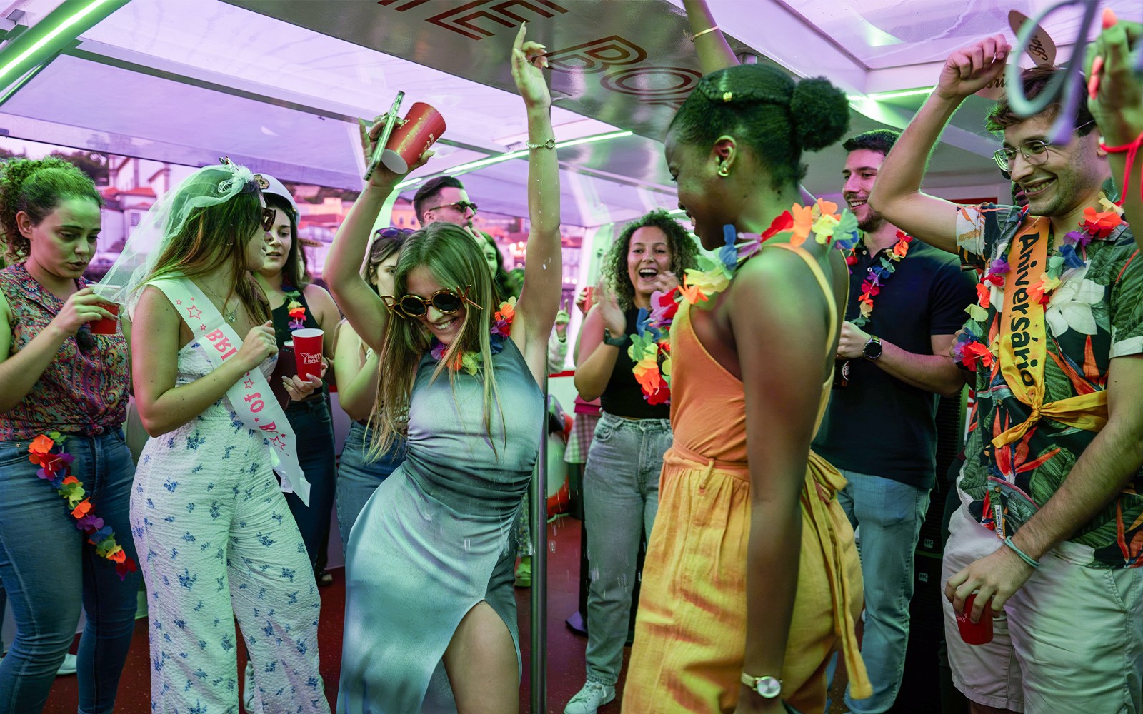 Festeiros dançando e celebrando em um cruzeiro no Rio Douro em Porto, Portugal.