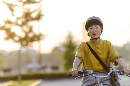 smiling young woman riding a bicycle