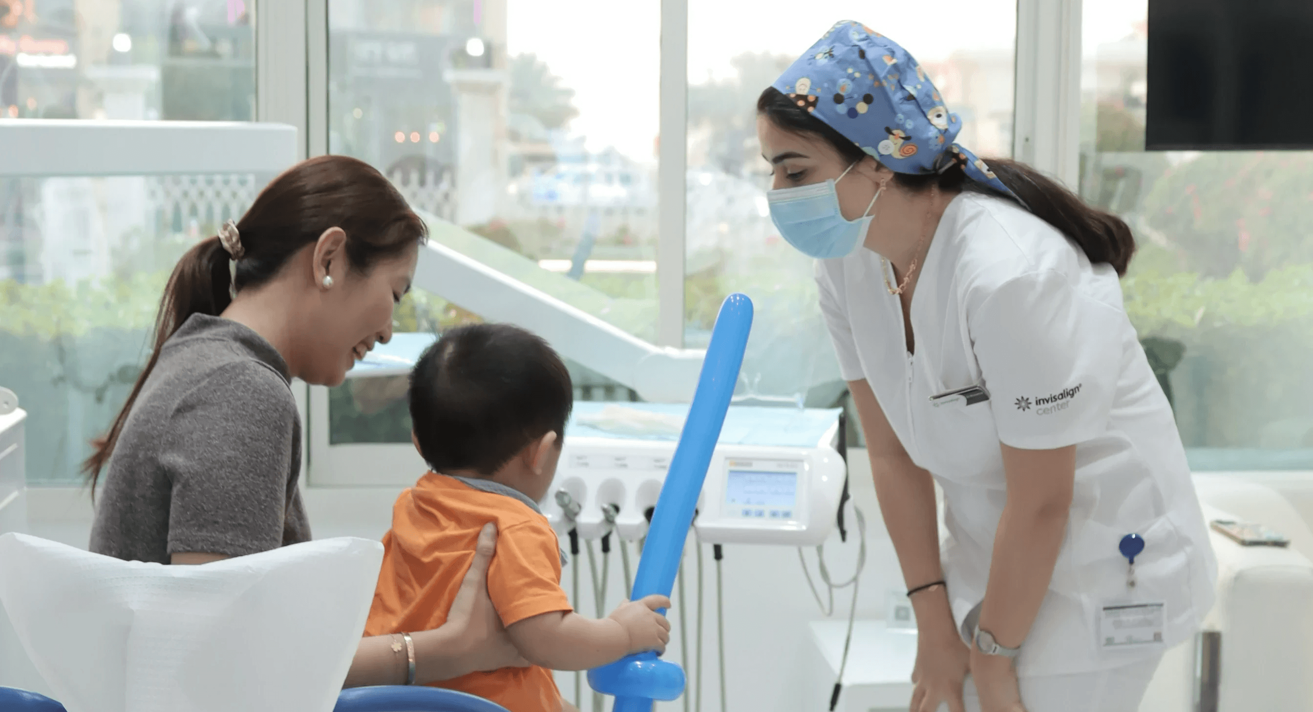 A mother holding her child after a dental visit, focused on preventing cavities in kids by Invisalign Center