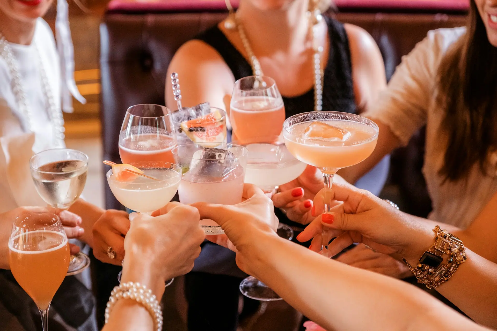 Friends raising cocktail glasses in a bar during a weekday gathering, highlighting a social midweek atmosphere.