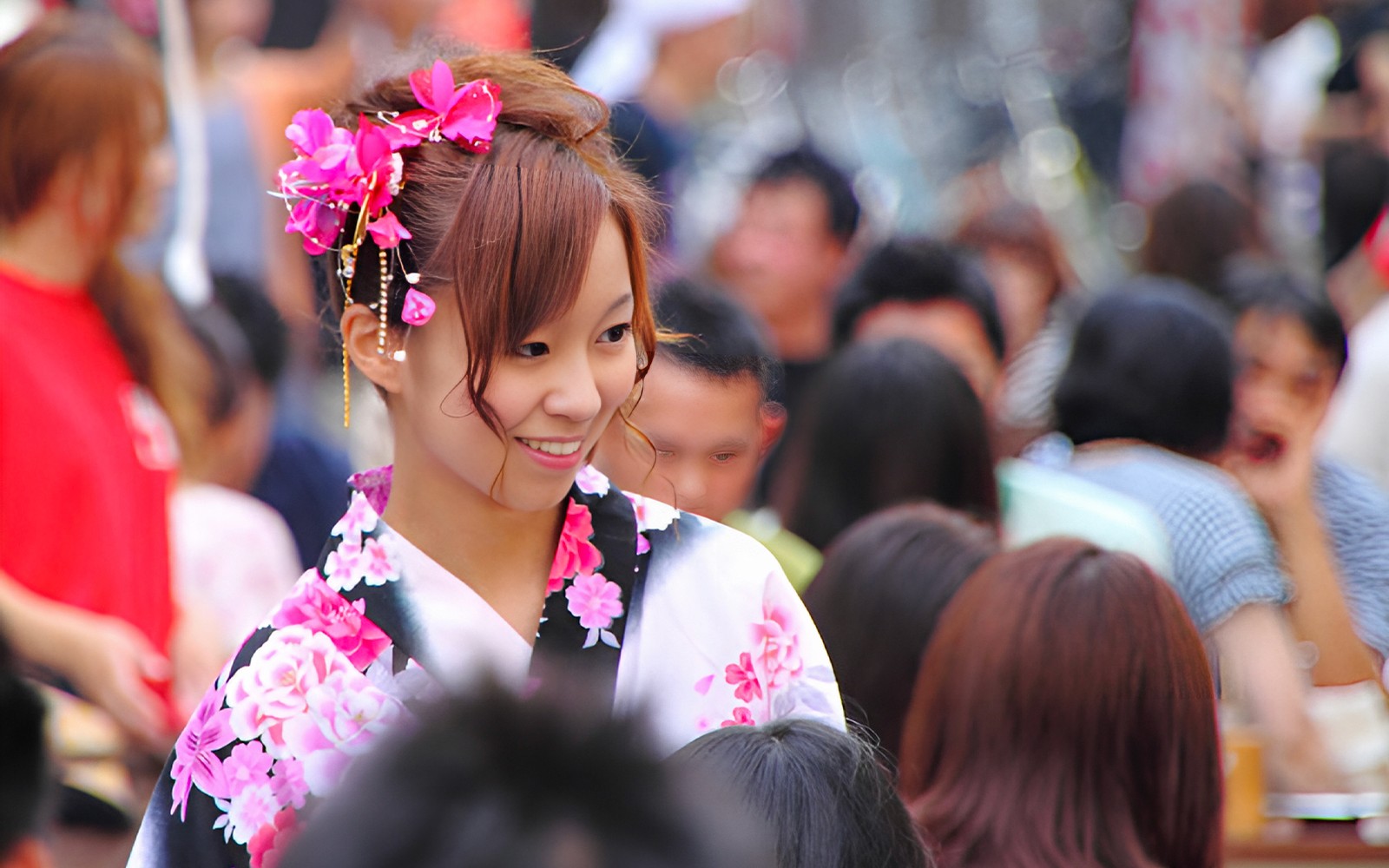 Kimono-clad individuals walking through Asakusa, Tokyo, with traditional architecture in the background.