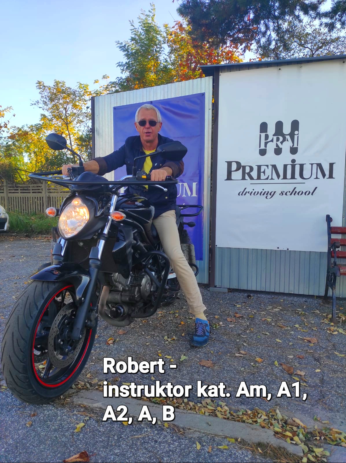 Robert – Instruktor siedzący na motocyklu przed budynkiem szkoły jazdy Premium.