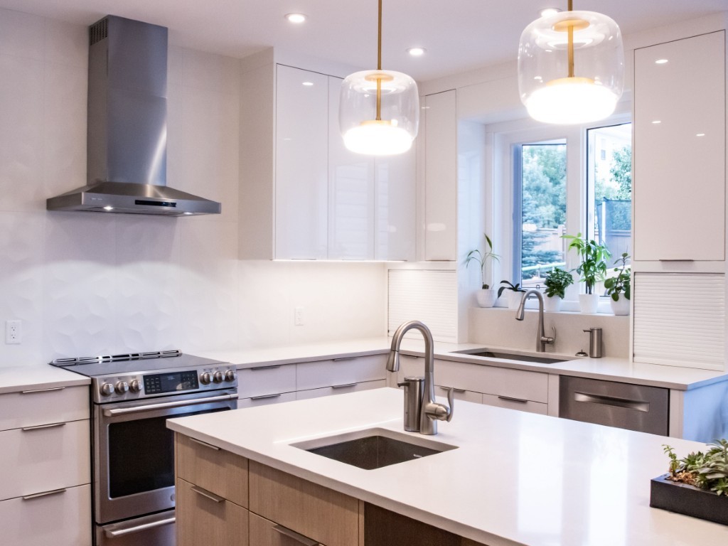 Image of Modern kitchen design with white countertops, stainless steel appliances, and pendant lighting by KHD Homes.