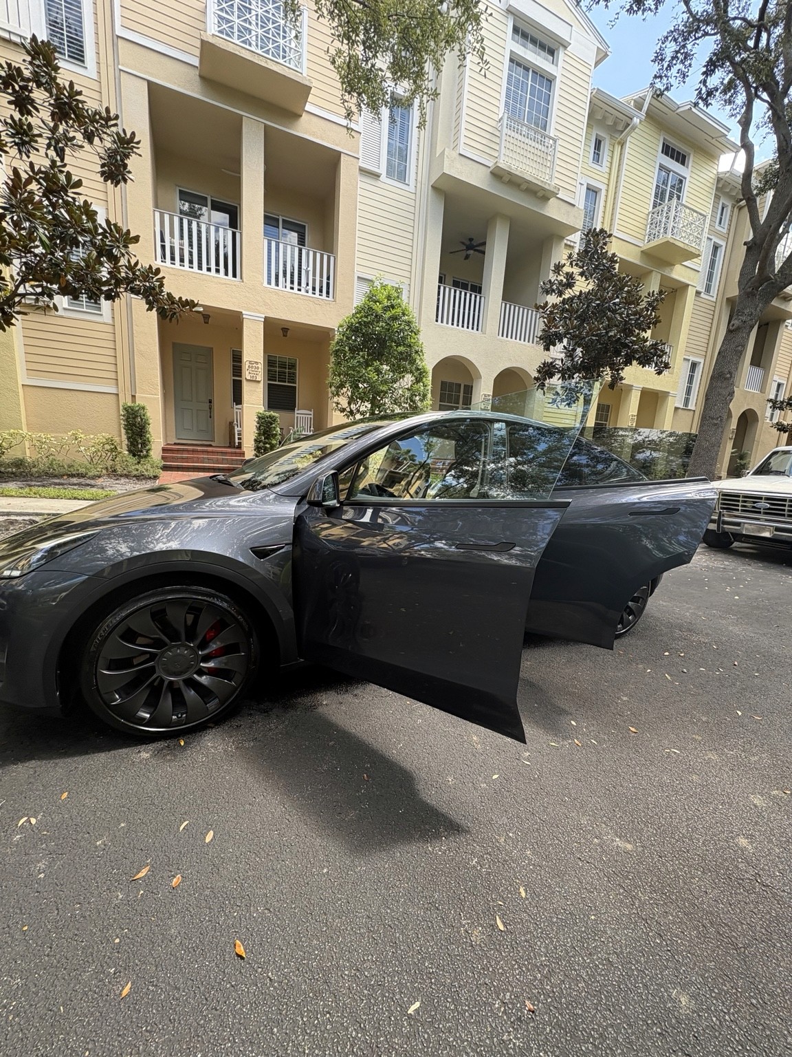 Side view of a gray Tesla Model Y during mobile detailing at a residential property
