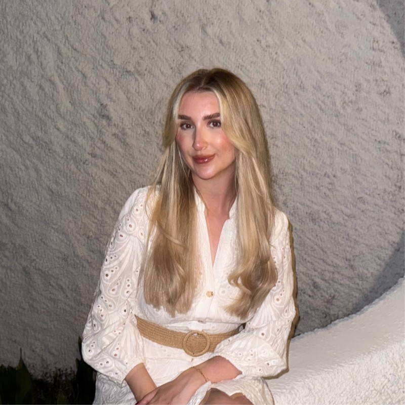 Woman in a beige turtleneck by an old computer and TV, retro 80s office portrait.