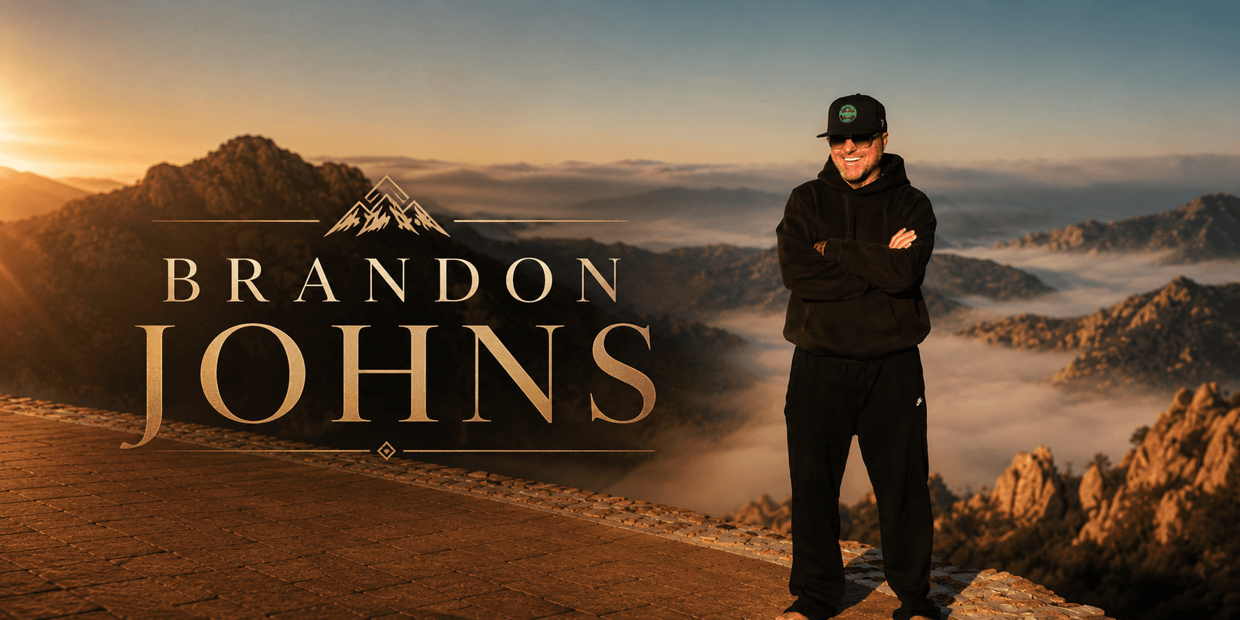 Brandon Johns standing on a mountain overlook at sunrise, promotional portrait for the Brandon from Georgia brand.