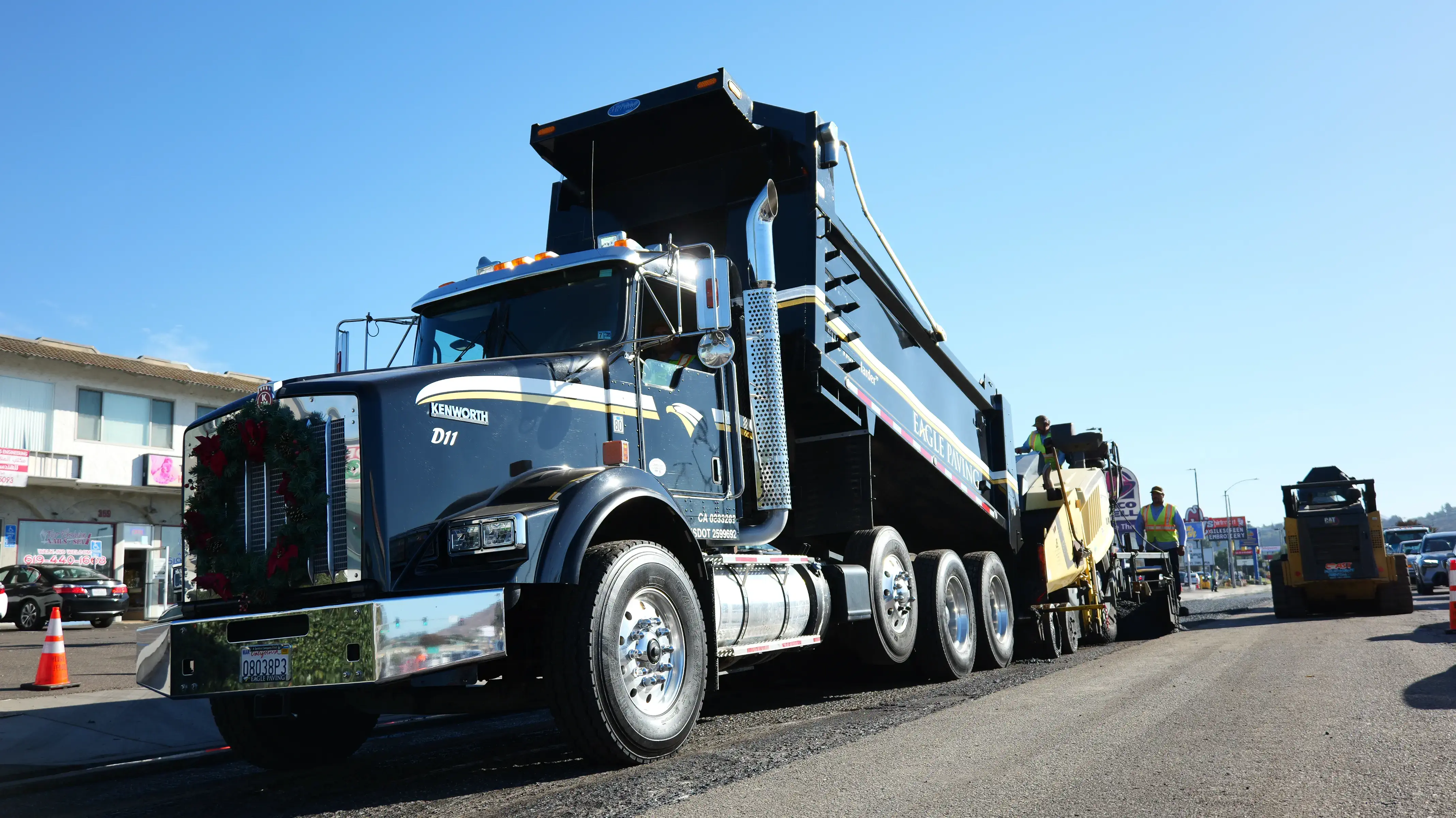 Dumptruck refilling paver machine with fresh hot asphalt