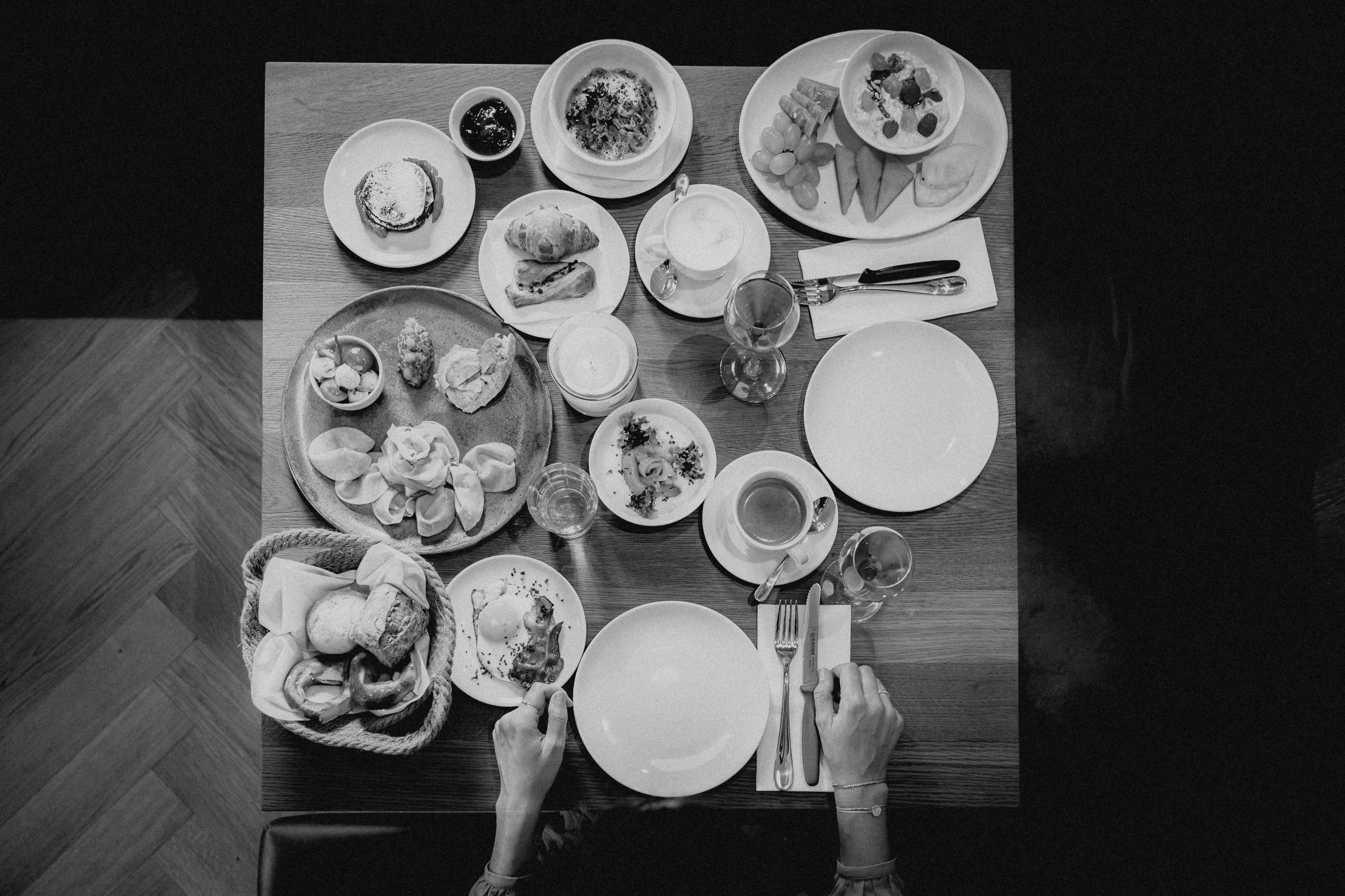 Aerial view of a table filled with various plates, bowls, and utensils, arranged in a visually interesting way.