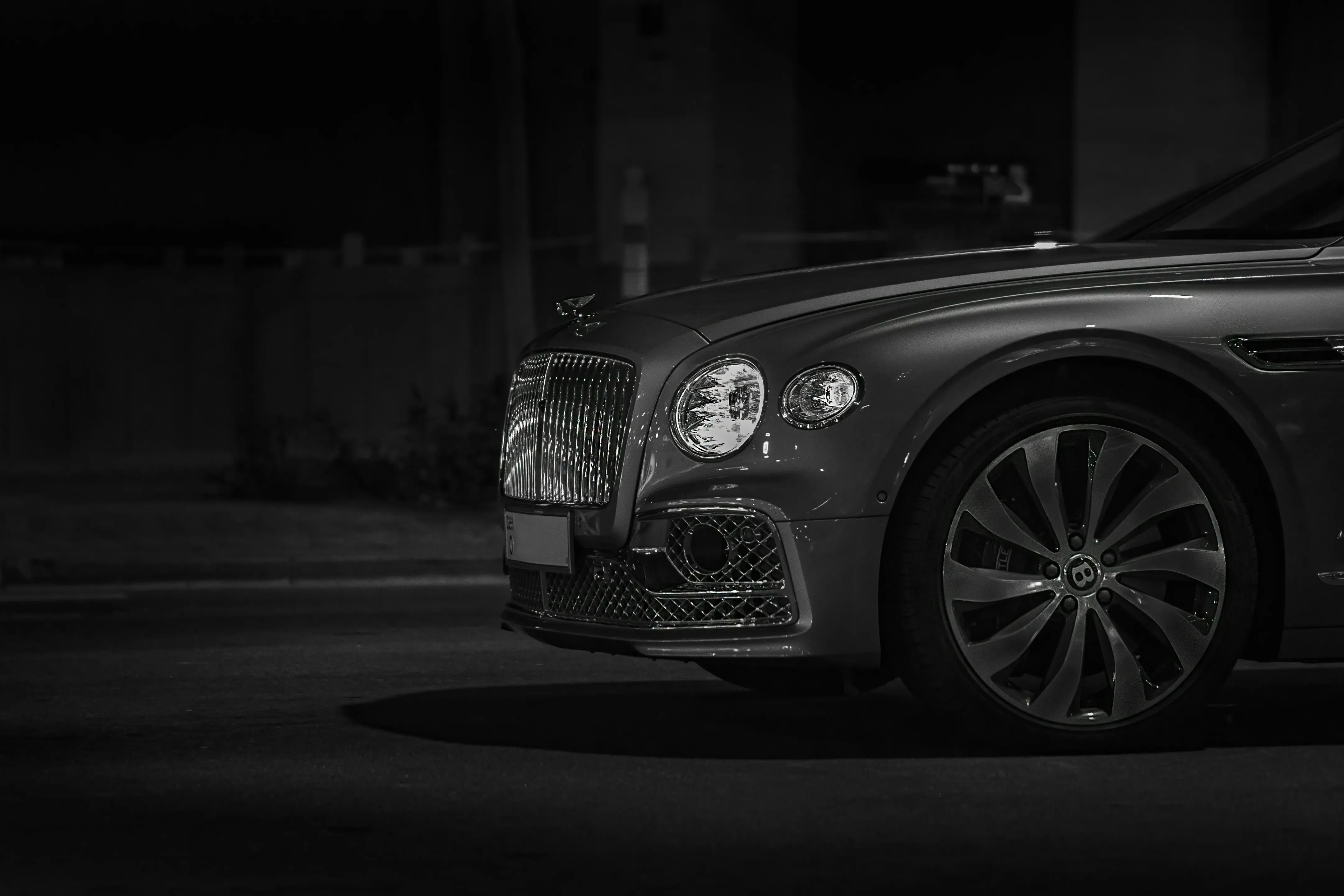 Black and white shot of a luxury car's front right side.