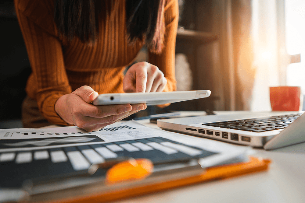 Woman in orange shirt using a tablet