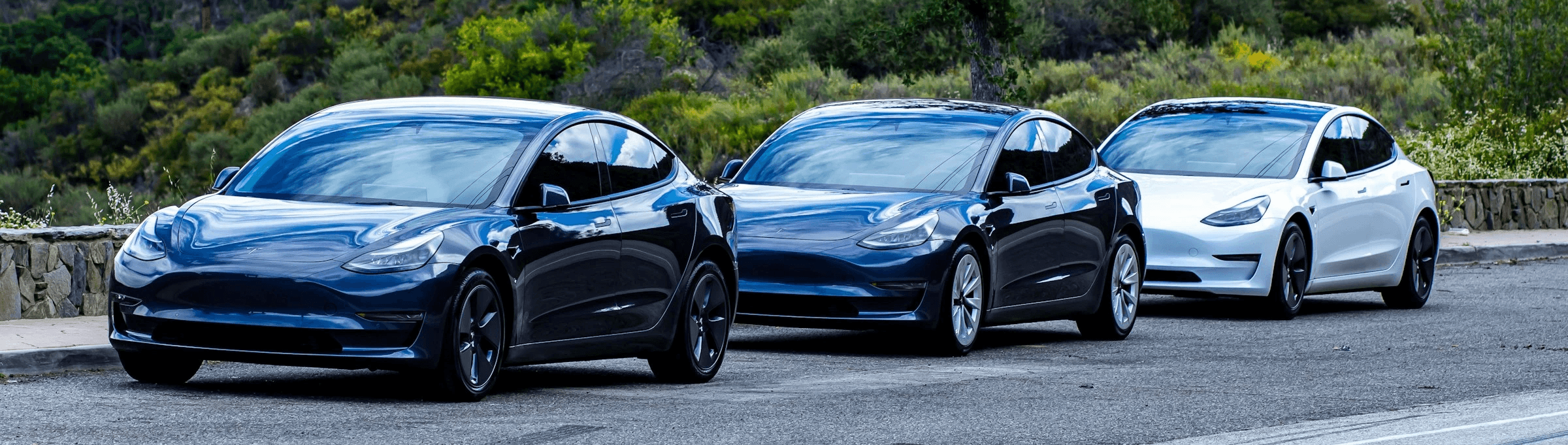 Plusieurs Tesla Model 3 stationnées côte à côte en extérieur, aperçu d’un groupe de berlines électriques