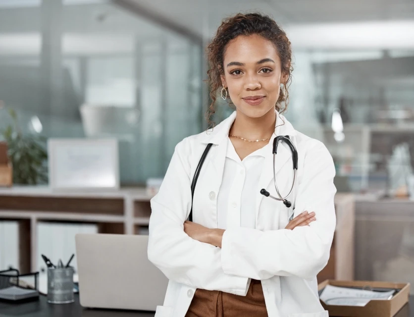 Mixed race woman doctor with arms crossed with a stethoscope around her neck