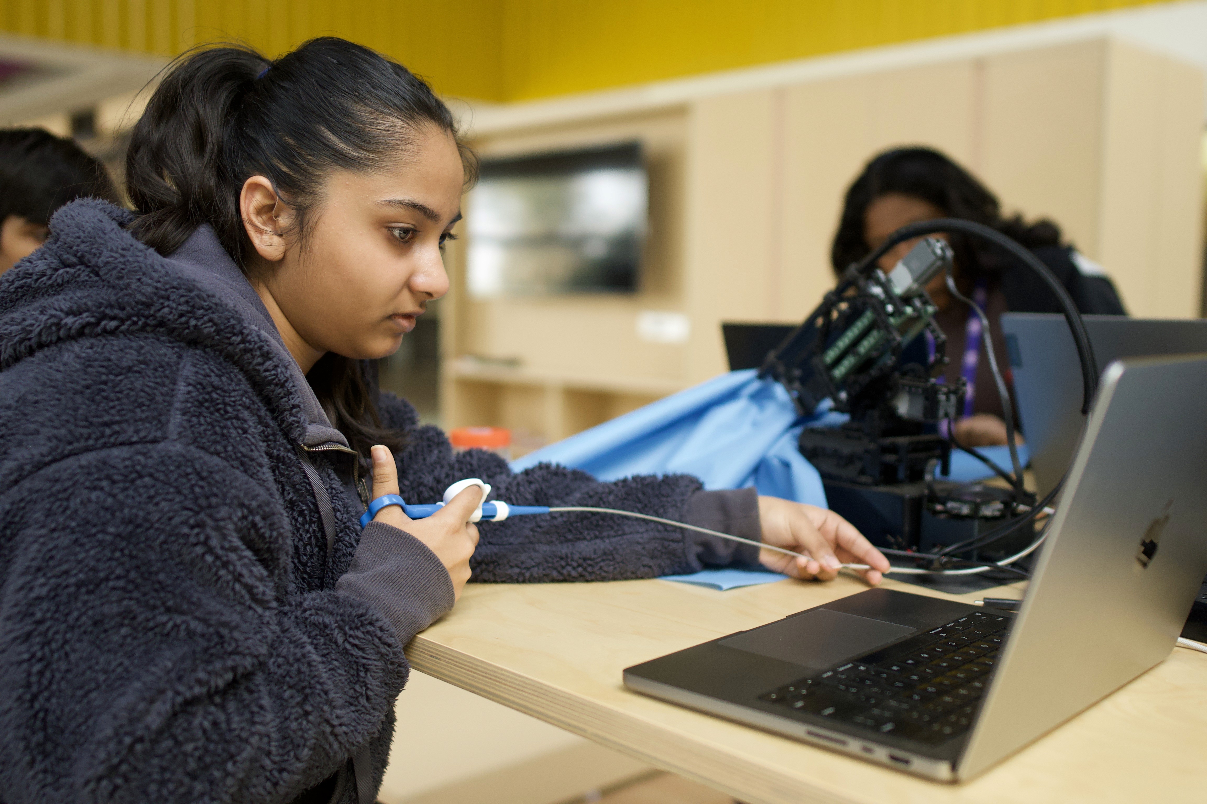 IB Student coding AI with VR headset and Mic Setup