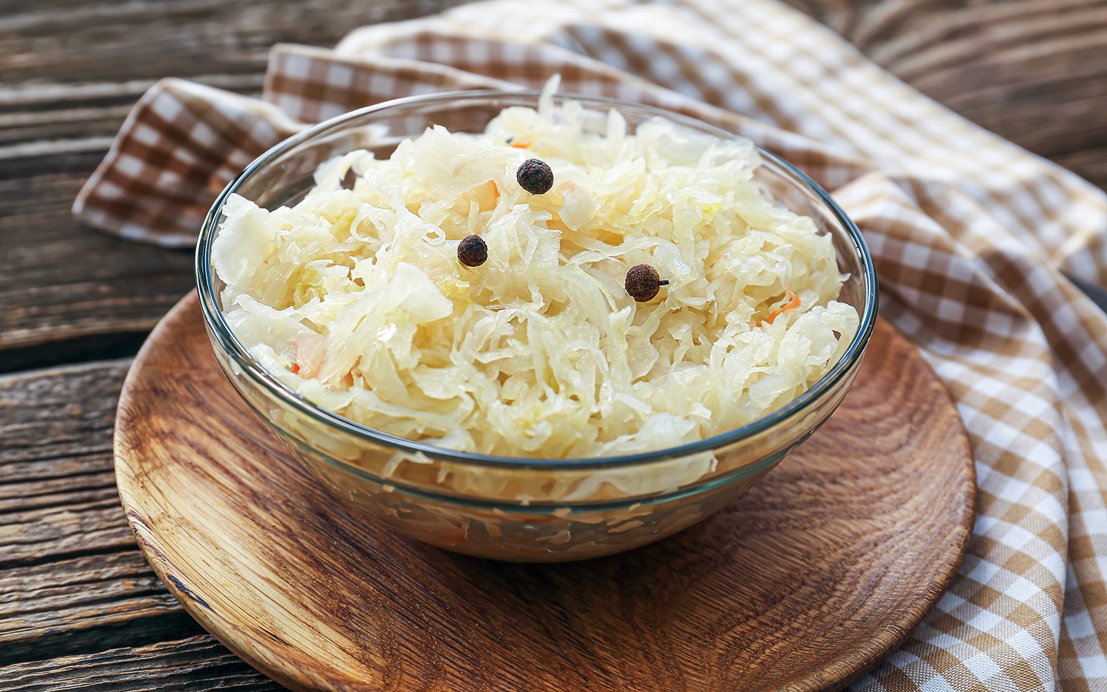 Cuenco de chucrut con granos de pimienta sobre una mesa de madera, Tour Gastronómico Callejero de Cracovia.