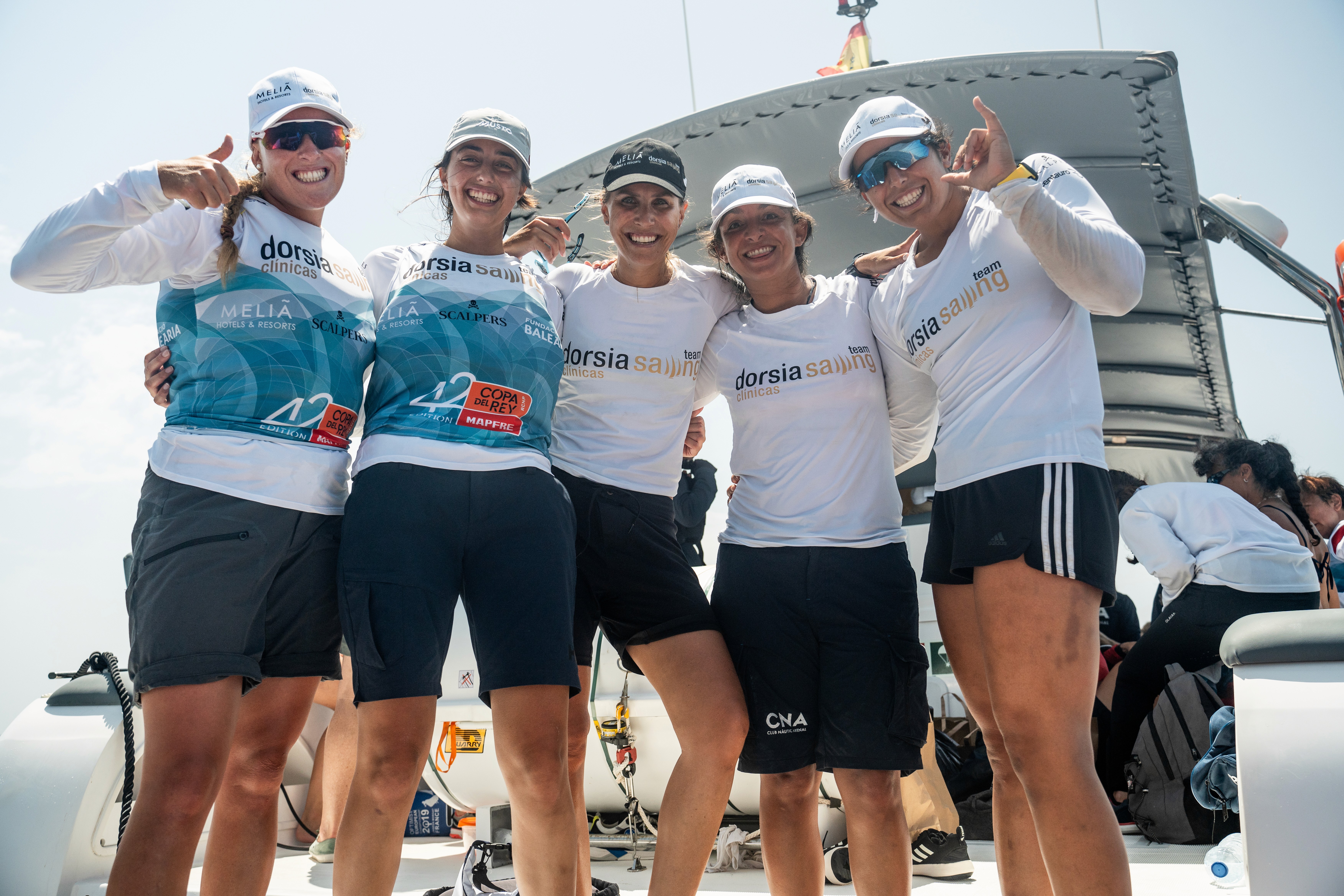 A woman wearing a shiny coat stands in focus, while a blurred background creates a sense of movement.