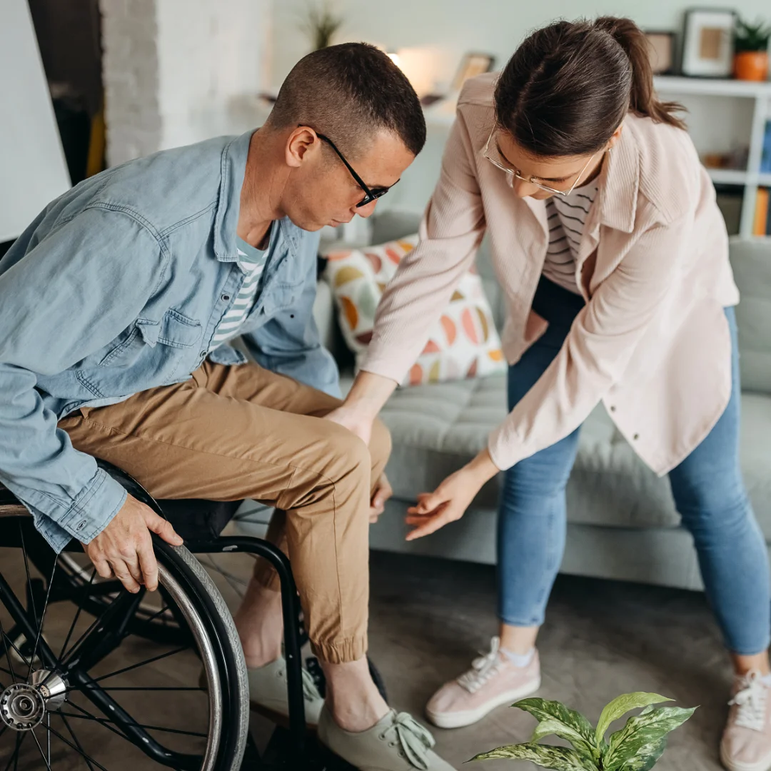 Community nurse and family member supporting person in wheelchair at home in Brisbane