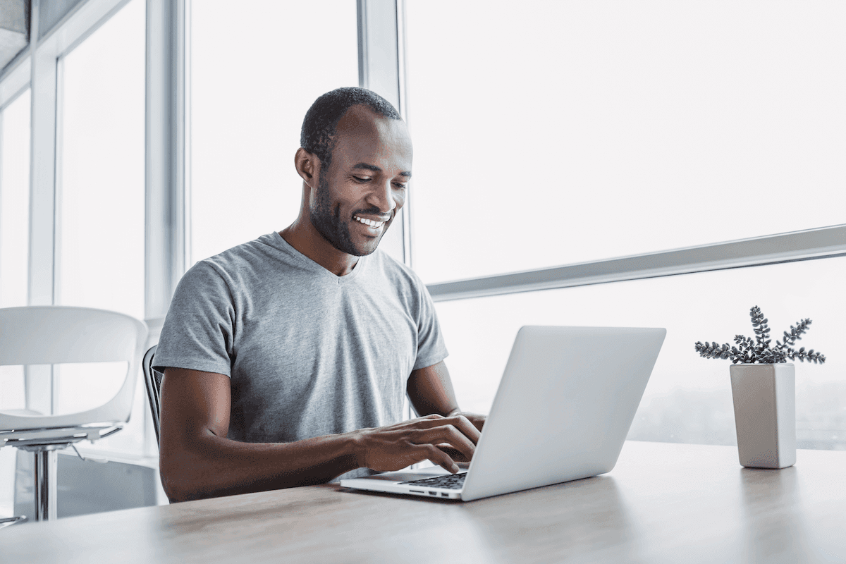 sales management software: man happily working on his laptop