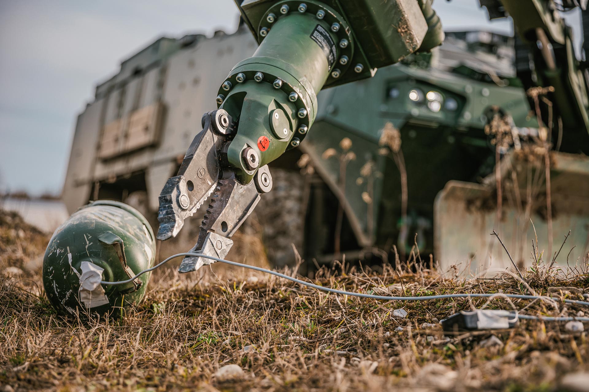 Close-up of GCS manipulator arm gripper handling an IED during route clearance operations.