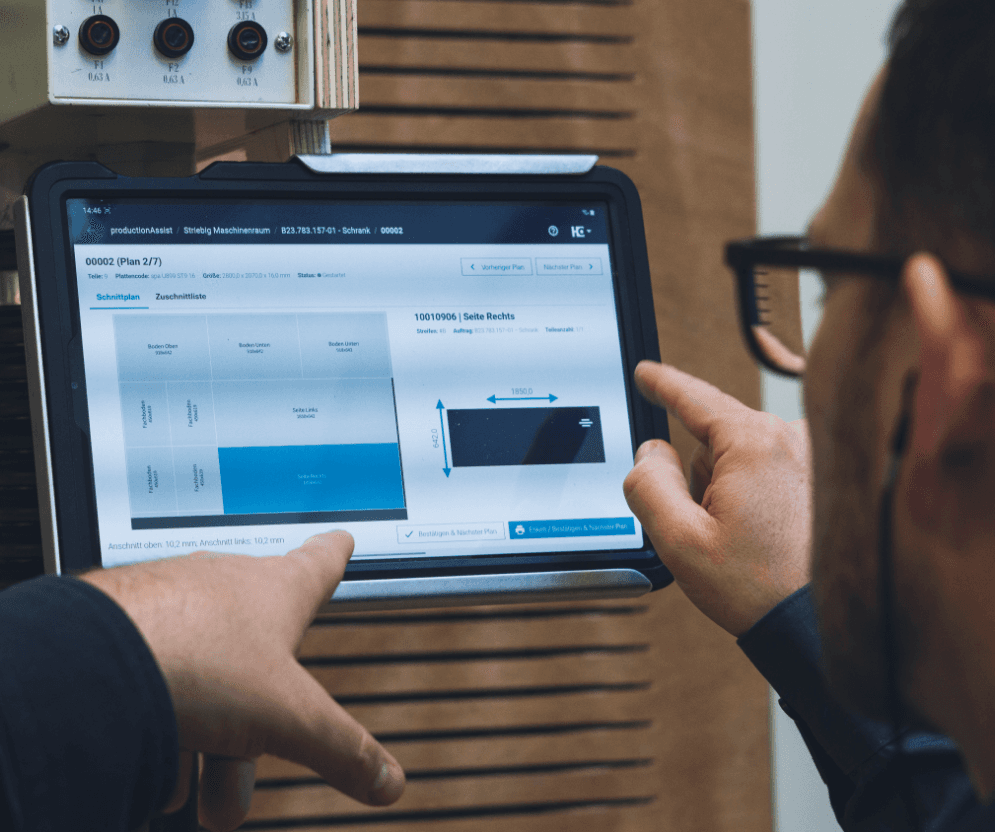 A carpenter operates the productionAssist on a tablet at a panel dividing saw.