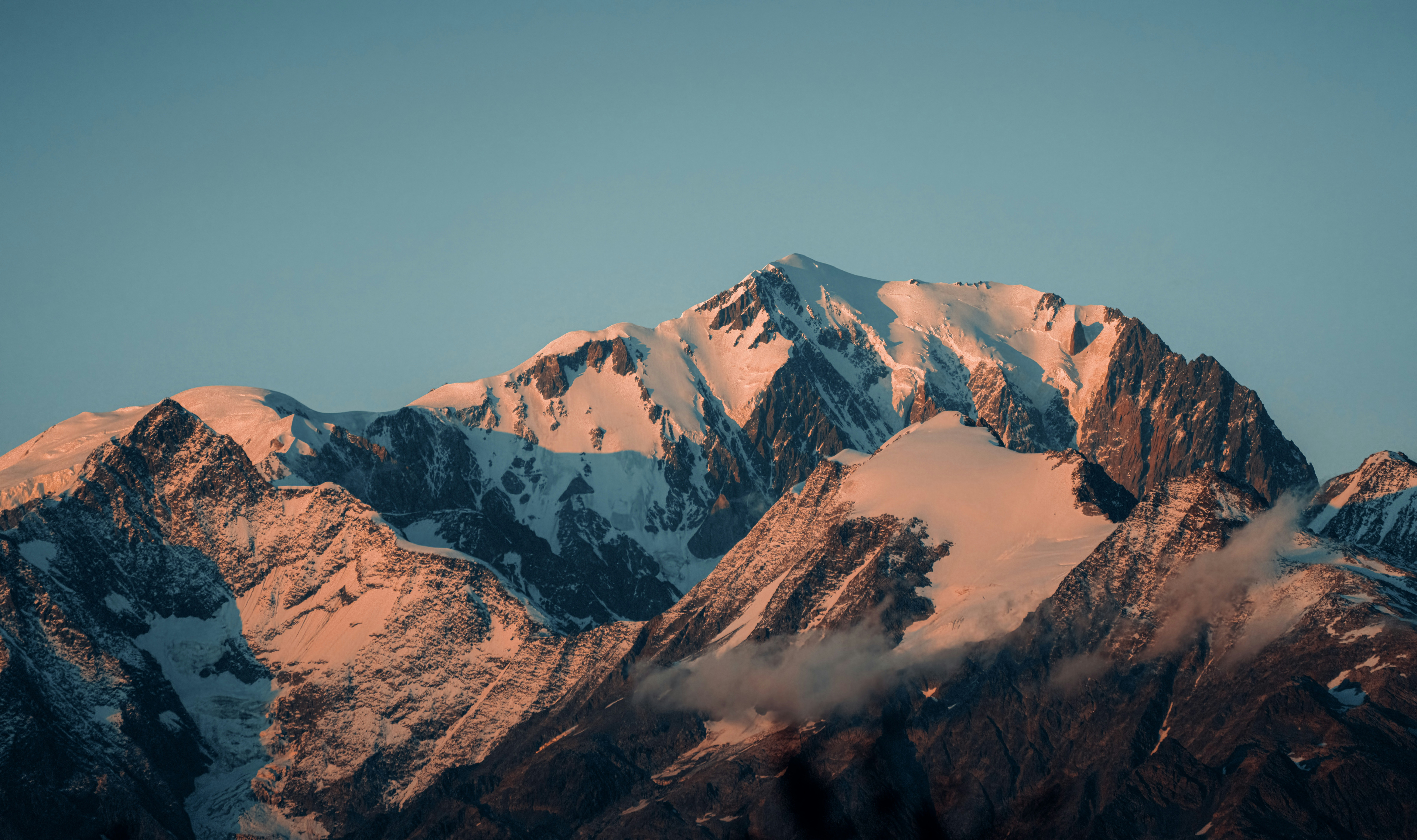 Snow-capped mountains bathed in warm sunset light
