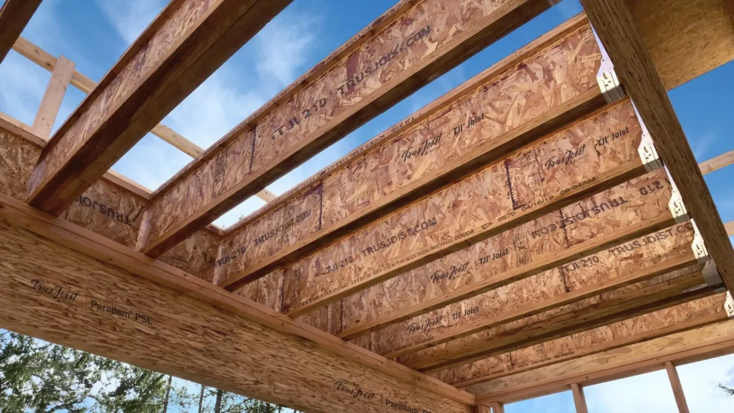 Flat-lay of curated material samples including stone tiles, textured fabrics, ceramics, and botanicals arranged on a neutral surface.