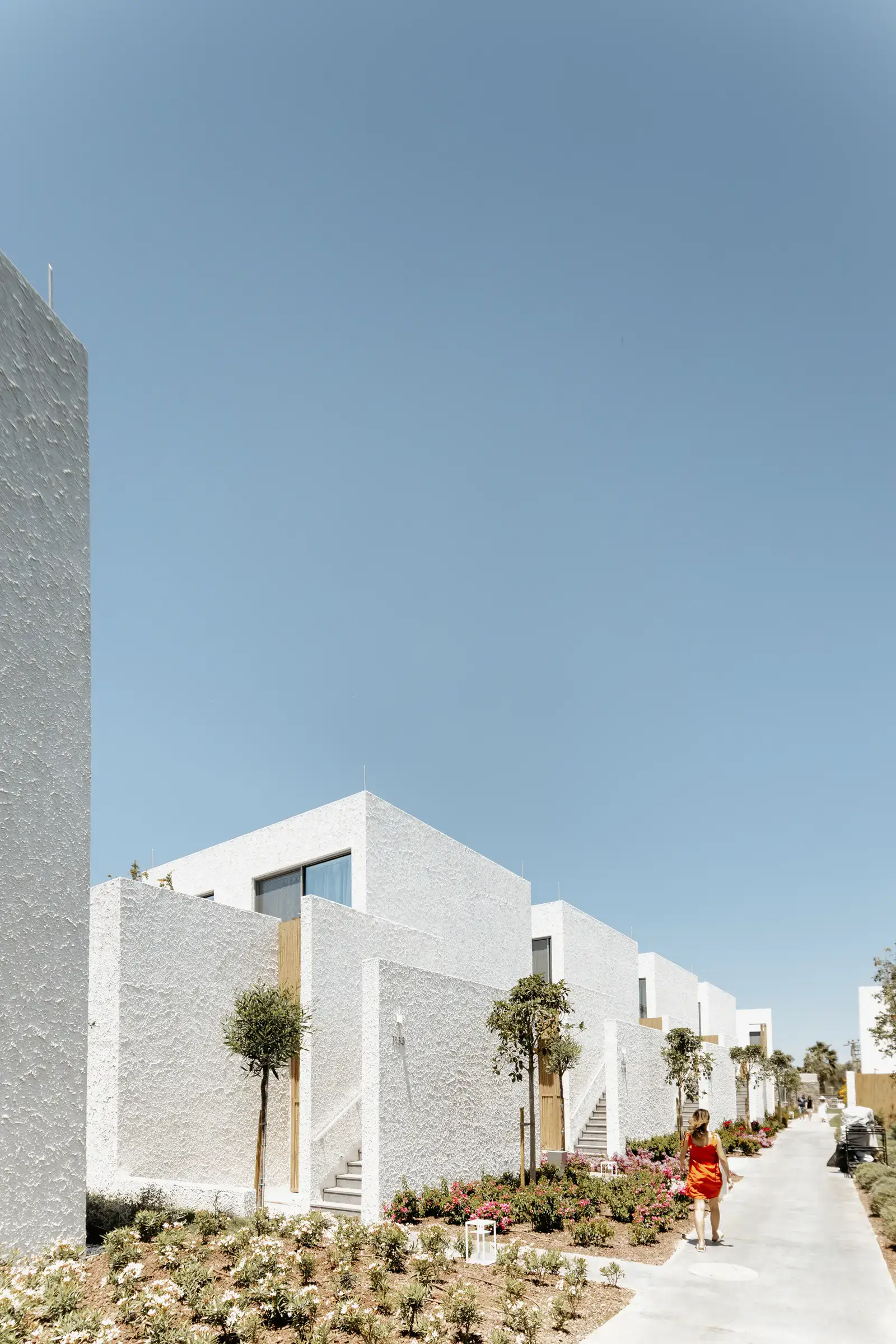 Path along the white buildings with people walking
